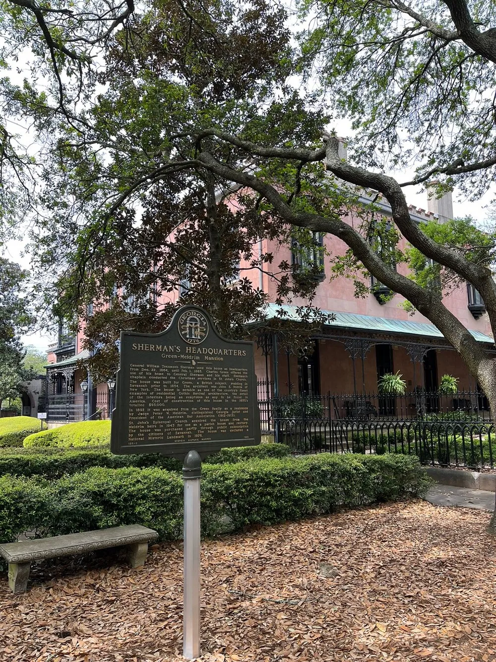 The image shows a historical marker indicating Shermans Headquarters in front of a large pink building surrounded by lush greenery and a sprawling live oak tree suggesting a site of historical significance