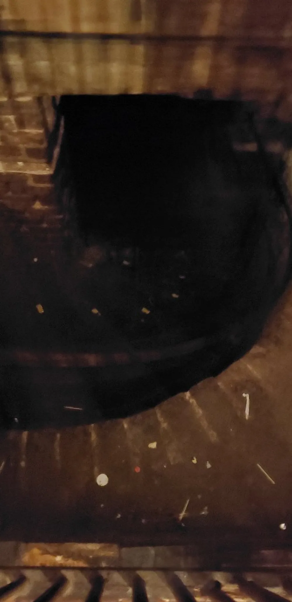 This is a dark blurry image that appears to show a poorly lit environment with indistinct features possibly an interior space with a reflective floor or wet surface