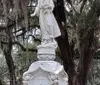 A person is giving a tour or presentation outdoors possibly in a historical or cemetery setting while gesturing with their hand