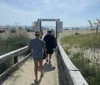 People are walking on a sandy boardwalk leading to North Beach on a sunny day