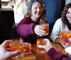 A group of people smiling and toasting with drinks appears to be enjoying a social gathering