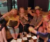 A group of people smiling and toasting with drinks appears to be enjoying a social gathering