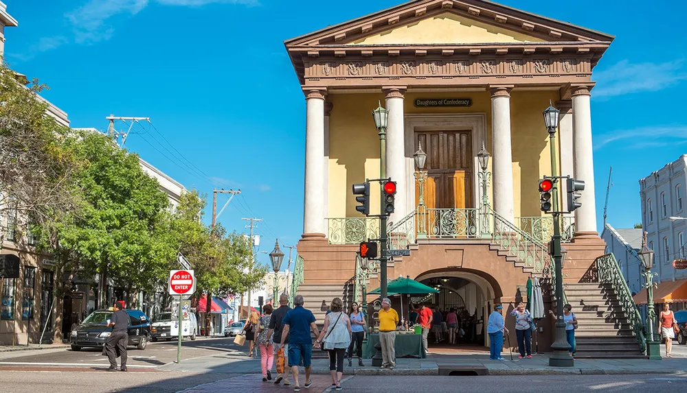 This image depicts a bustling street scene with pedestrians and a car in front of an elegant building with a sign reading Daughters of Confederacy under a clear blue sky