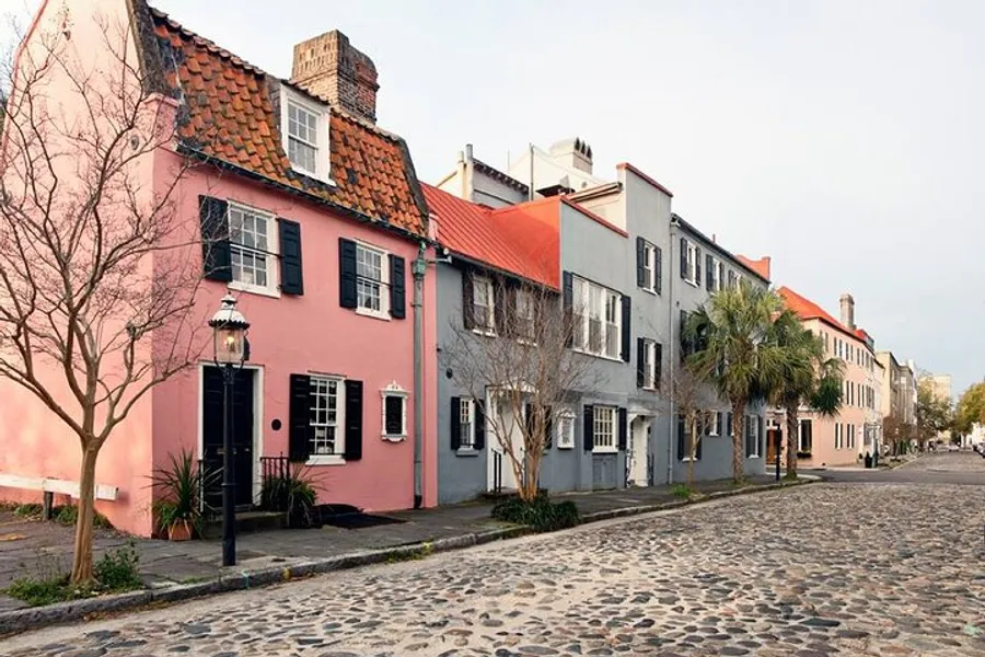 A cobblestone street is flanked by colorful houses, exhibiting a charming, old-world aesthetic.