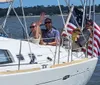 A group of people is enjoying a sunny day sailing on a boat adorned with the American flag