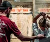 A man is instructing a woman on how to throw an axe at an indoor axe-throwing venue