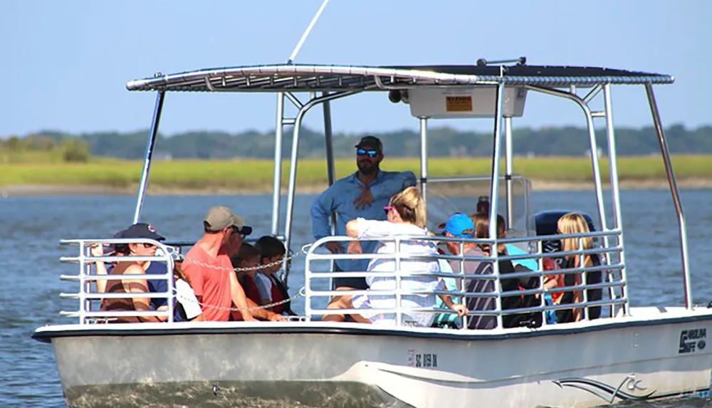 A group of people enjoys a sunny boat tour with a guide standing at the helm