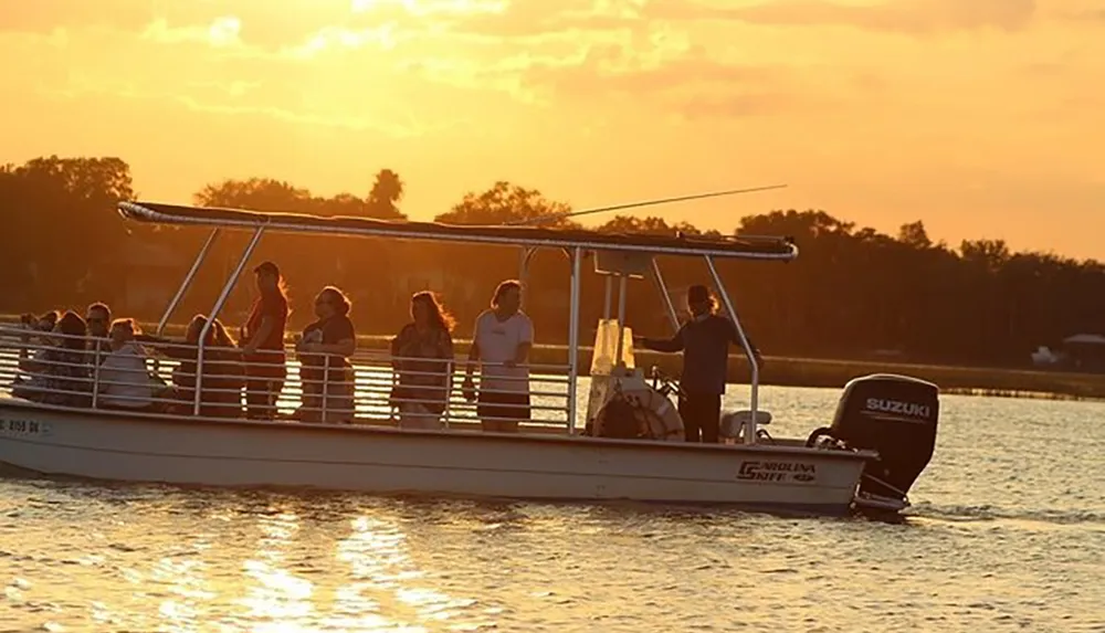 A group of people enjoys a serene boat ride during a golden sunset