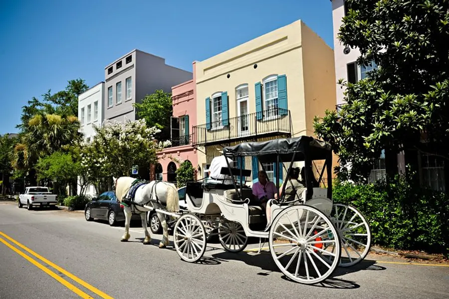 A horse-drawn carriage waits on a sunny street lined with colorful buildings.