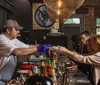 A chef in a casual restaurant is serving a dish to a customer across the bar in a cozy dimly lit dining atmosphere