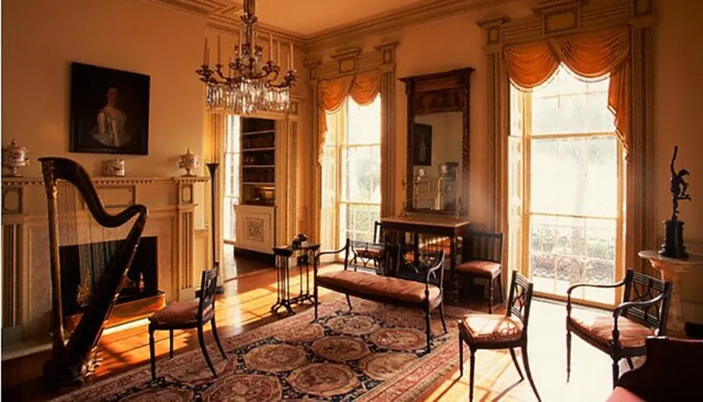 This image shows a warmly lit elegant vintage room with a harp chandelier ornate furniture and classical decor