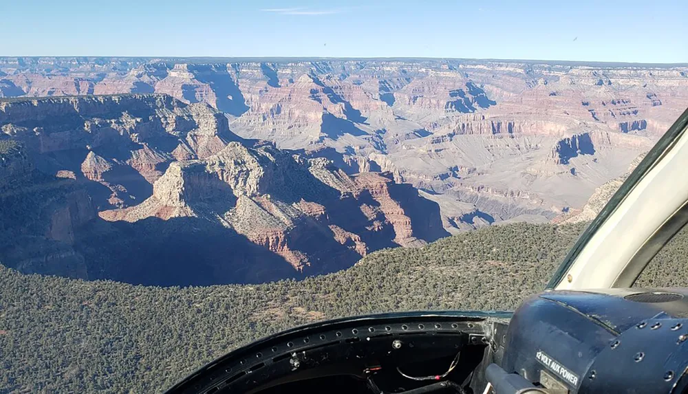 The image shows an aerial view of the Grand Canyon as seen from the cockpit of an aircraft