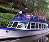 A boat named YELLOW THUNDER is carrying a group of passengers through a scenic waterway surrounded by lush forests and rock formations