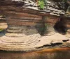 A tour boat named Chicagow is navigating between two large rock formations carrying passengers exploring a scenic waterway