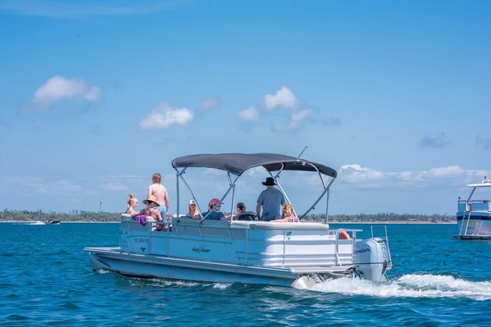 A group of people is enjoying a sunny day out on the water aboard a pontoon boat