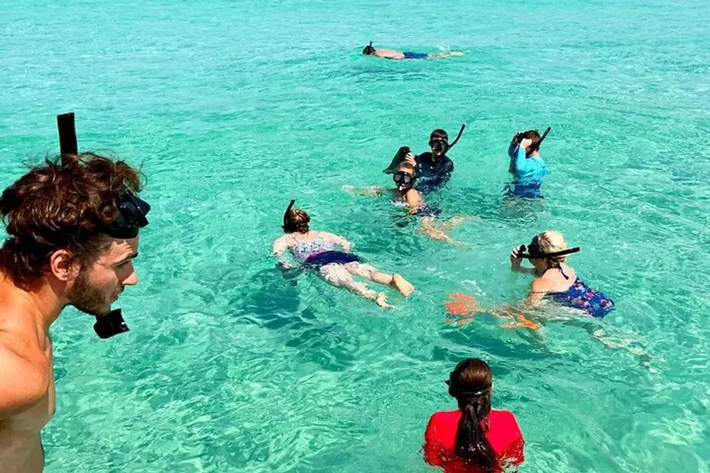 A group of people are enjoying snorkeling in clear turquoise waters