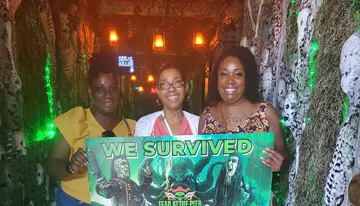 Three people are smiling and holding a sign stating 