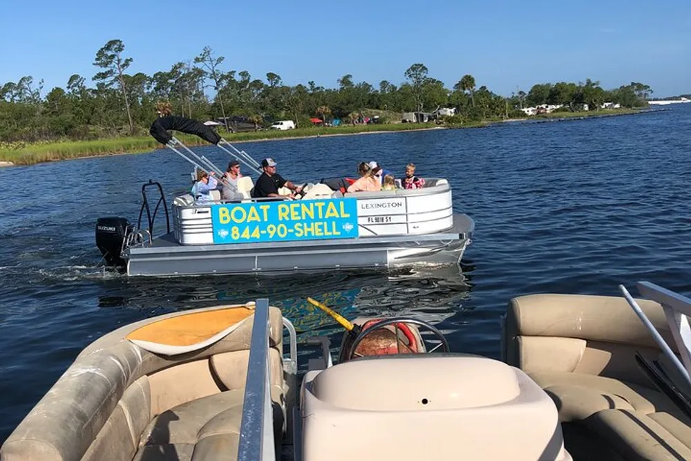 A group of people enjoys a sunny day on a rented pontoon boat while another boat is in the foreground