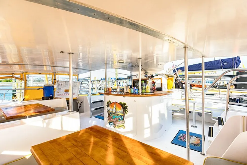 The image shows a bright and inviting interior of a boat with a bar area wooden furniture and a view of the marina outside