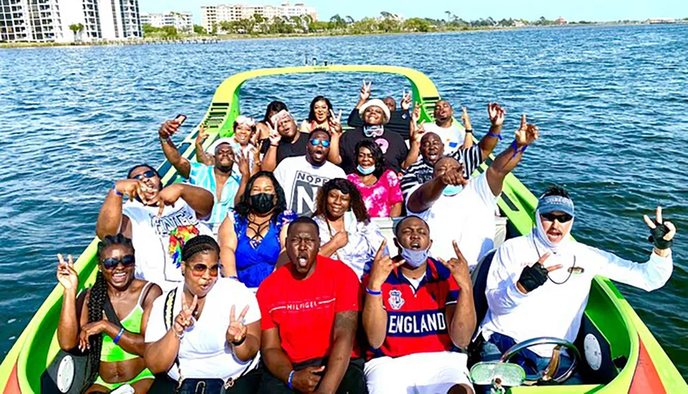A group of joyful people are posing for a photo on a colorful boat making various hand gestures and expressing happiness