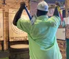 A person is poised to throw an axe at a wooden target in an indoor axe throwing facility