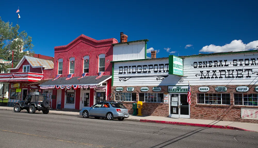 The image shows a sunny street view with vintage American storefronts including a general store with patriotic decorations under a clear blue sky