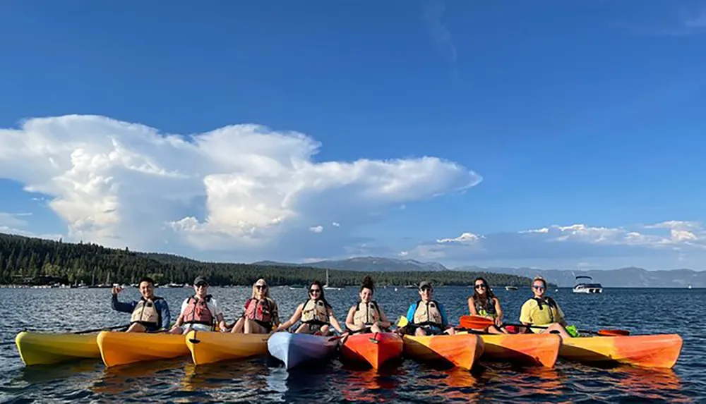 A group of people enjoy kayaking together on a calm lake under a sky with impressive cloud formations