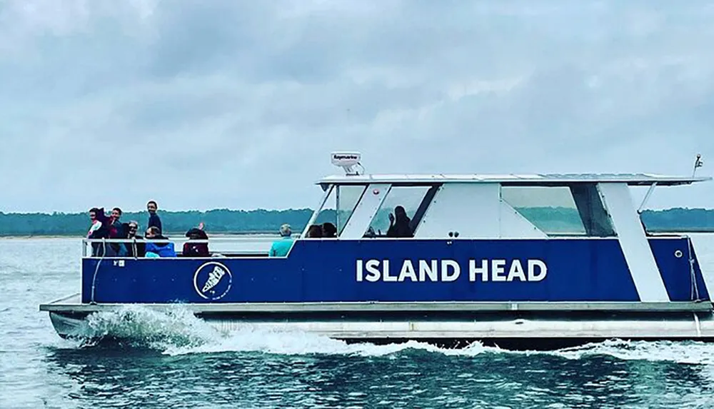 A group of people are enjoying a boat ride on a vessel named ISLAND HEAD