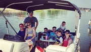 A group of people, including children and adults, are enjoying time together on a boat on a sunny day.