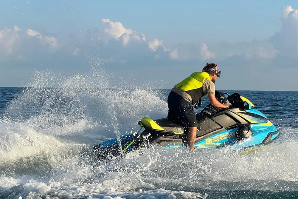 A person is actively maneuvering a jet ski over the ocean waves creating a dynamic splash of water