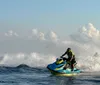A person is actively maneuvering a jet ski over the ocean waves creating a dynamic splash of water