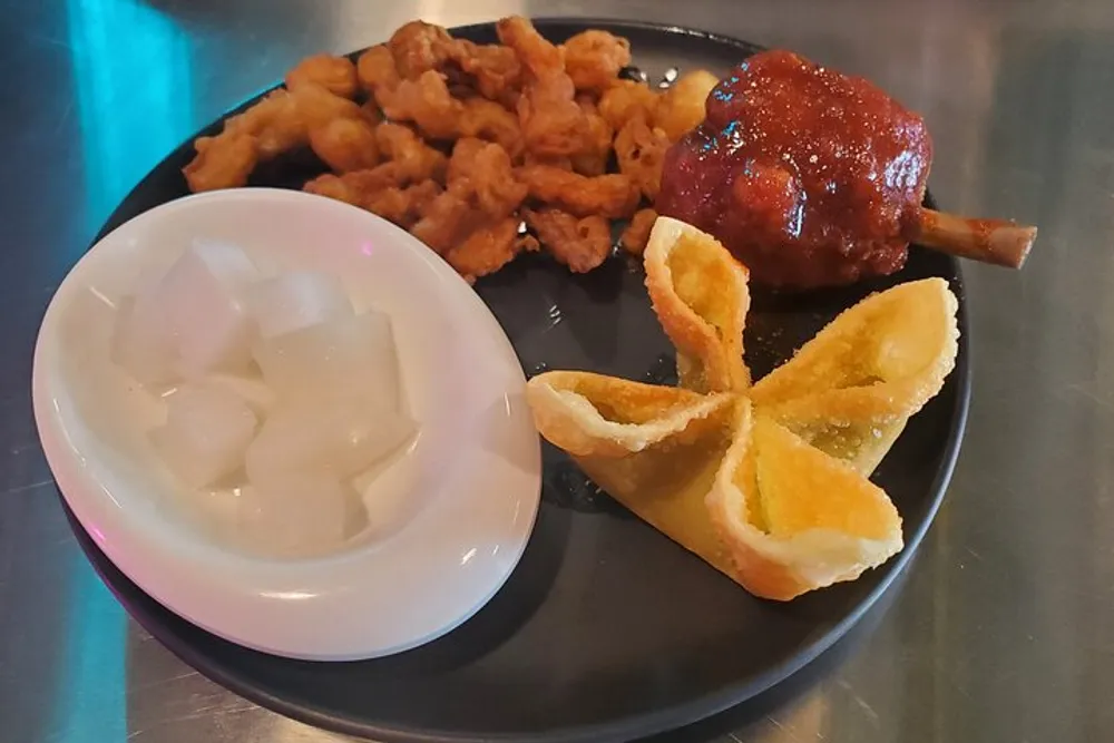 The image features a plate with assorted appetizers including fried calamari a glazed meatball on a stick cream cheese wontons and a side of pickled radish