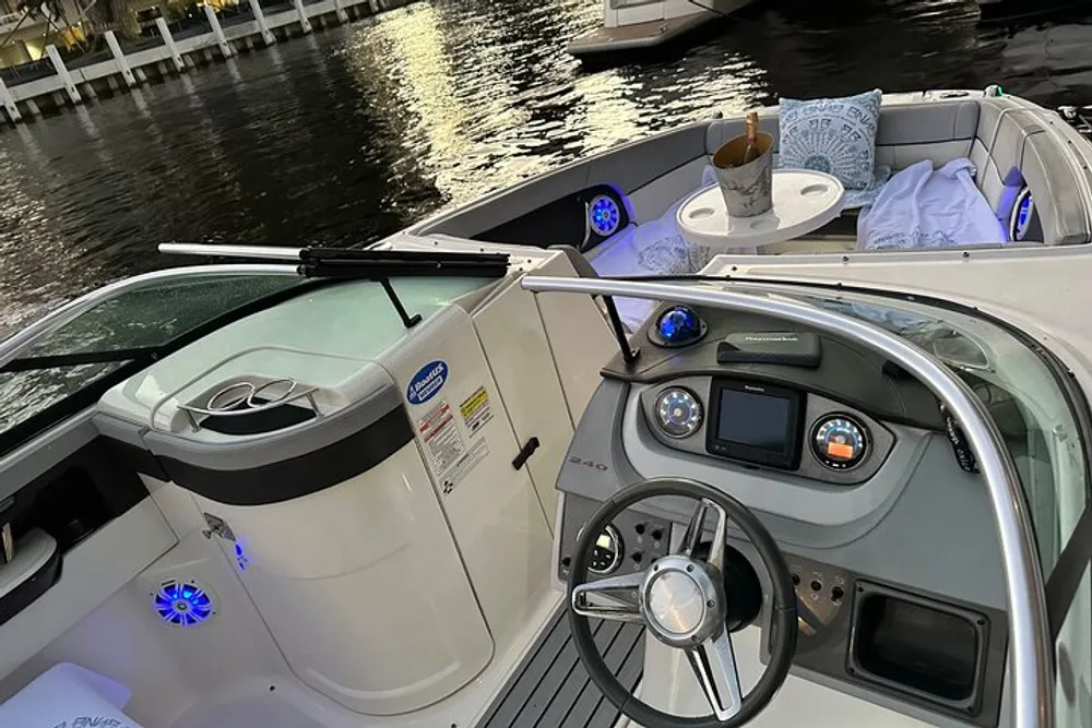 The image shows the cockpit area of a modern leisure boat equipped with a steering wheel instrument panels and comfortable seating docked at a waterfront
