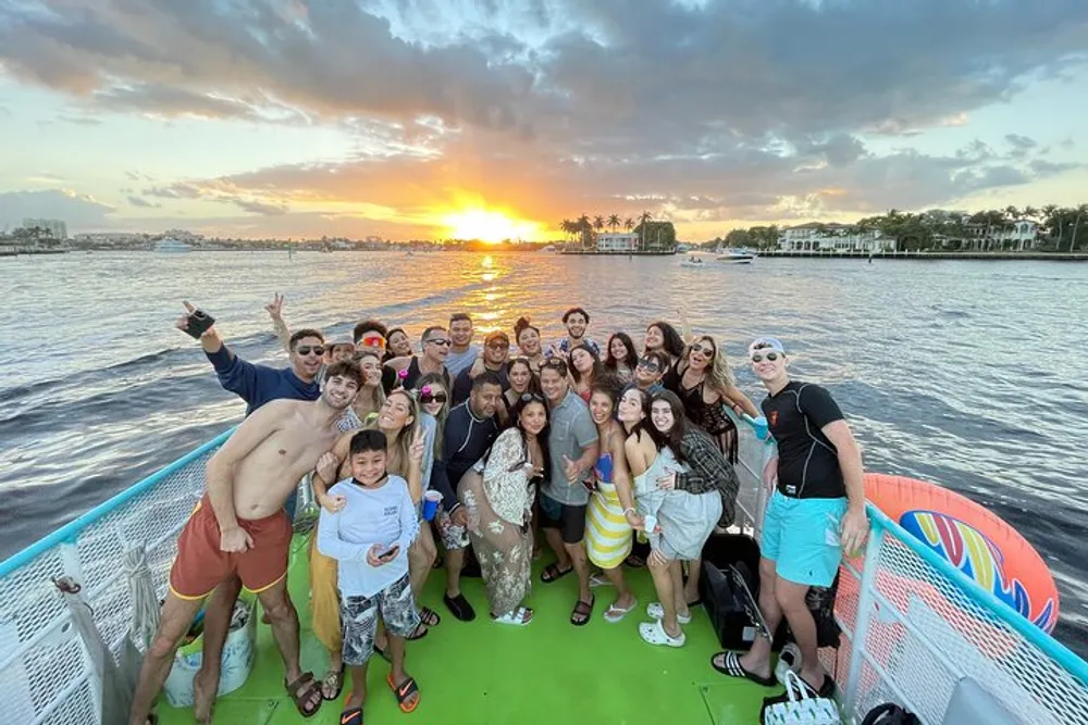 A group of people is posing for a photo on a boat with a beautiful sunset in the background