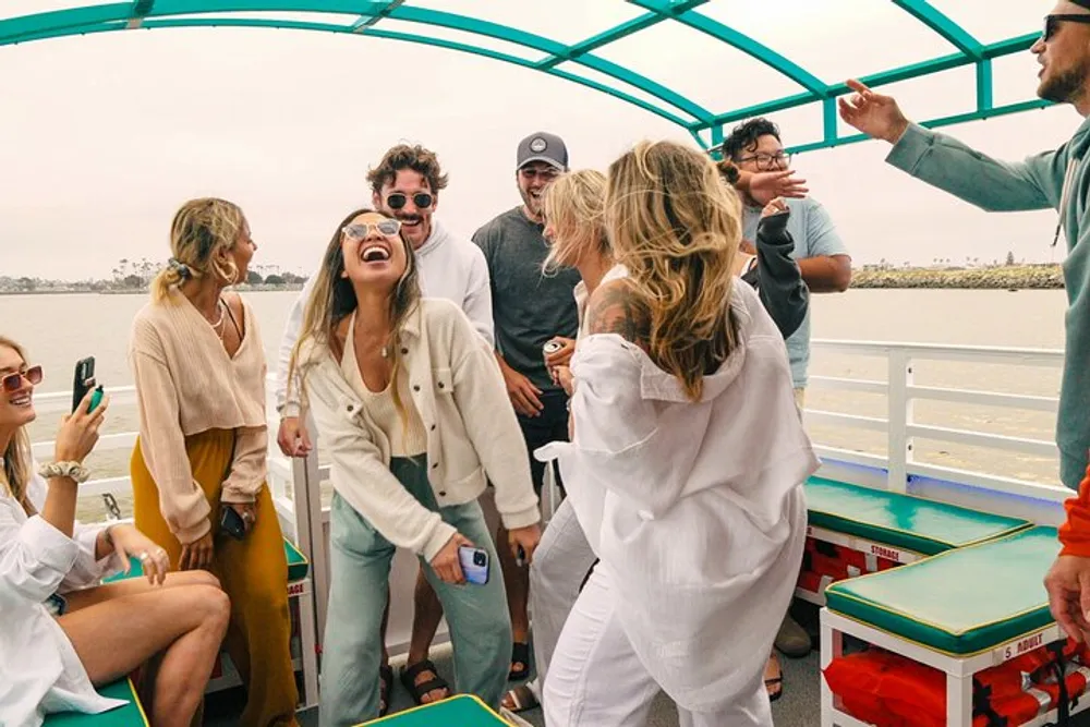 A group of cheerful people is enjoying a lively gathering on what appears to be a boat sharing laughter and conversation