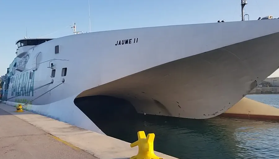 The image shows a large ferry named Jaume II, docked at a port beside the water.