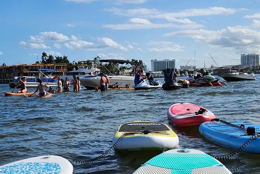 The image shows a group of people enjoying water activities with paddleboards and boats on a bright sunny day