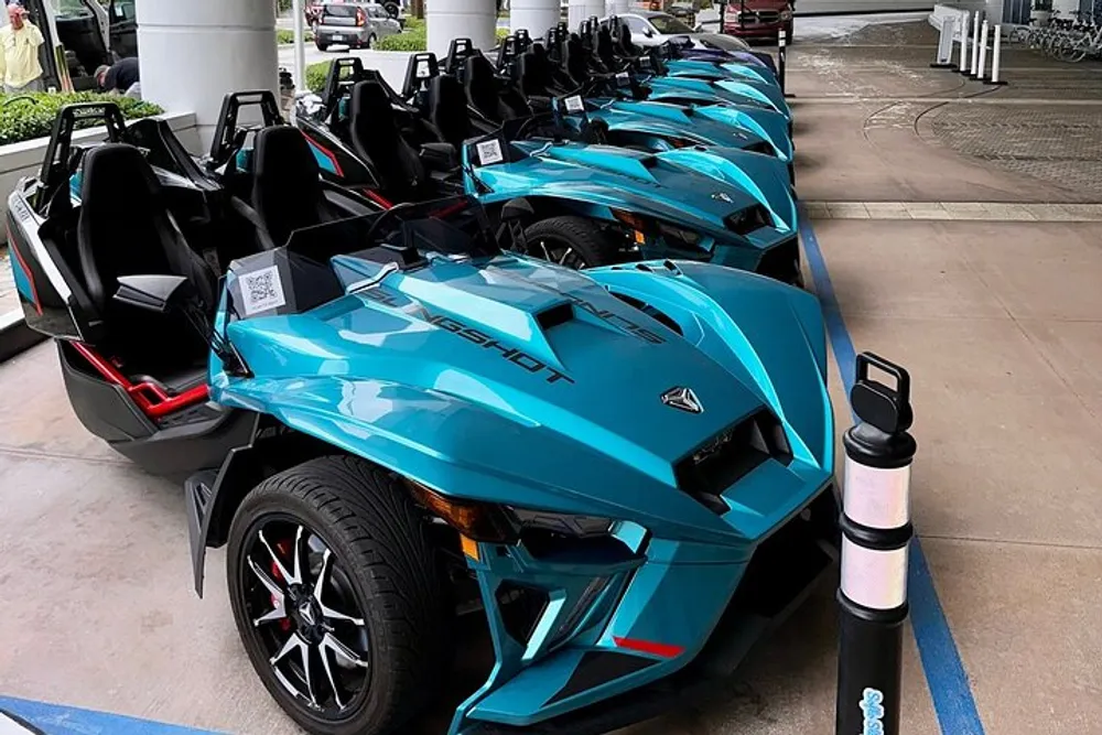 A row of blue Polaris Slingshot vehicles is lined up perhaps available for rent or sale