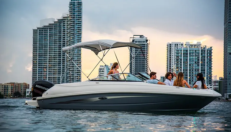 A group of people enjoys a boat ride near a city's waterfront skyline at dusk.