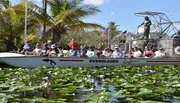 A group of passengers is seated on an airboat named