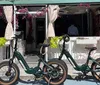 A man and a woman are smiling and posing with their bicycles on a sunny pier suggesting a leisurely day out
