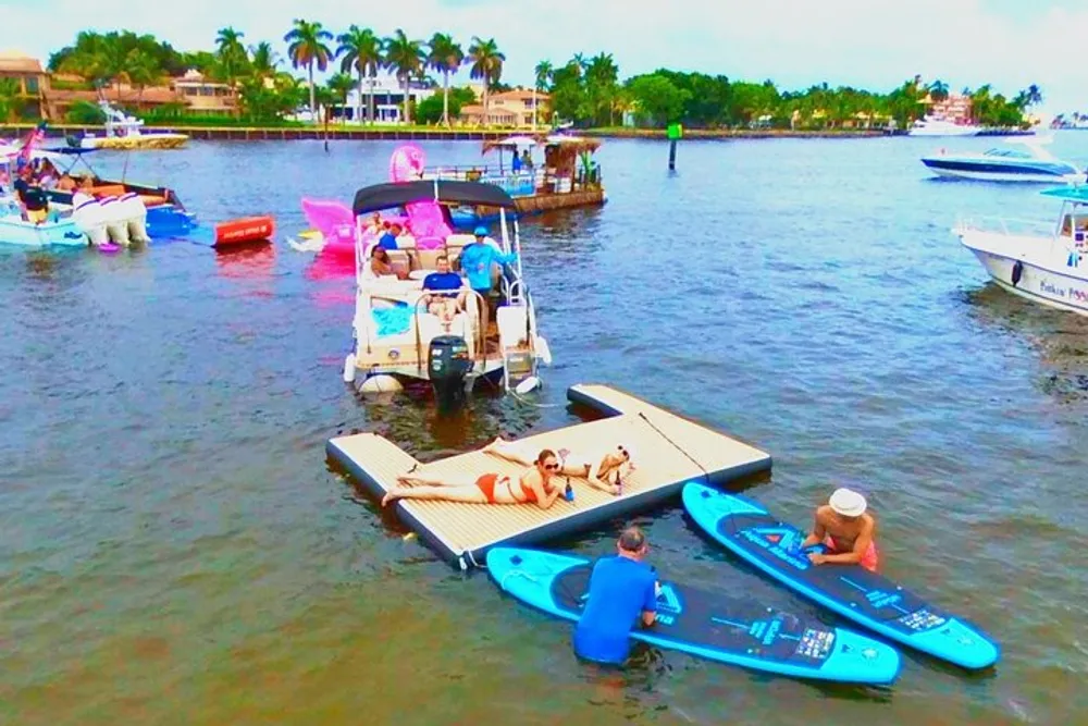 The image shows a vibrant and busy waterway scene with individuals engaging in various recreational activities such as paddle boarding and boating in a tropical setting