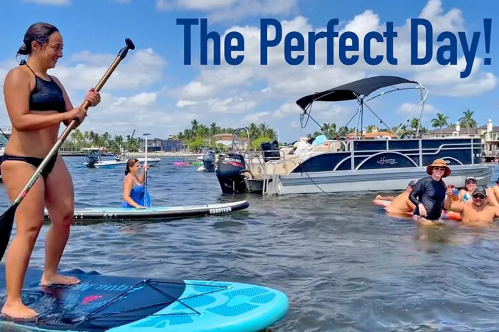 The image shows a sunny day on the water with individuals paddleboarding and enjoying a boat ride highlighted by the phrase The Perfect Day indicating a joyful and leisurely atmosphere