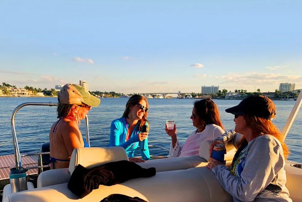 A group of people is enjoying a boat ride and drinks while basking in the warmth of the setting sun