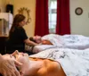 A person is receiving a back massage from a massage therapist in a relaxing spa-like environment