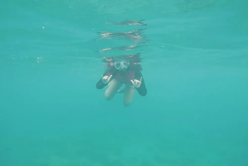 A person is snorkeling in clear turquoise water