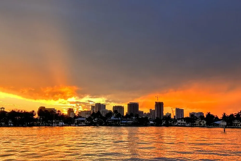The image shows a vibrant sunset with orange and blue skies over a city skyline reflected on a large body of water