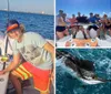 A person is holding a large fish with a big smile on their face standing on a boat with the ocean in the background