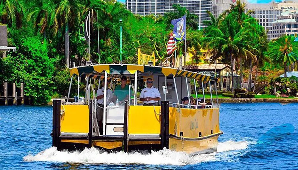 A water taxi with passengers is cruising along a river surrounded by lush tropical foliage
