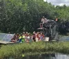 People are taking a tour on an airboat in a grassy wetland area